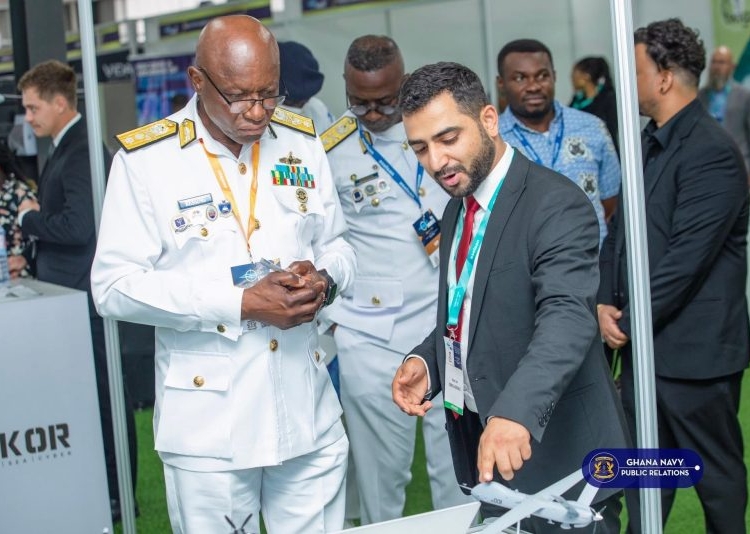 A representative from Milkor showing the 380 UAV to naval personnel at the IMDEC 2025.