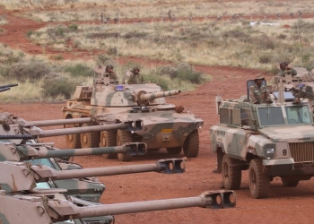 A Mamba mine resistant ambush protected armoured personnel carrier and Rooikat armoured reconnaissance car position themselves in front of a row of Ratel 90 infantry fighting vehicles, at South African Army Combat Training Centre Lohatlha's Mount Huxley during the Exercise VUKUHLOME IV 2025 Distinguished Visitors Day capability demonstration.