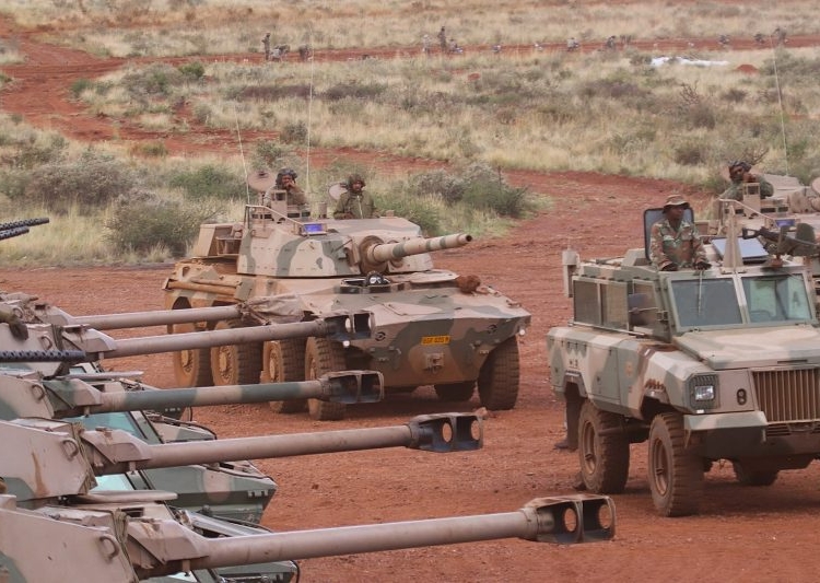 A Mamba mine resistant ambush protected armoured personnel carrier and Rooikat armoured reconnaissance car position themselves in front of a row of Ratel 90 infantry fighting vehicles, at South African Army Combat Training Centre Lohatlha's Mount Huxley during the Exercise VUKUHLOME IV 2025 Distinguished Visitors Day capability demonstration.